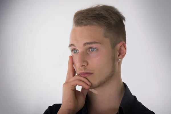 Aantrekkelijke jonge man denken, op zoek weg — Stockfoto