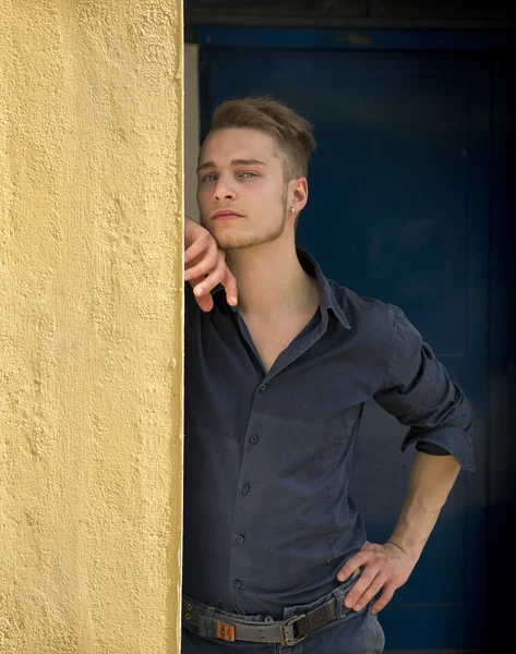 Attraktive junge blonder Mann an die Wand gelehnt — Stockfoto