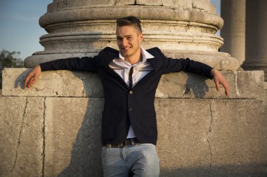 yakışıklı sarışın genç adam onun arkasında mermer sütun ile