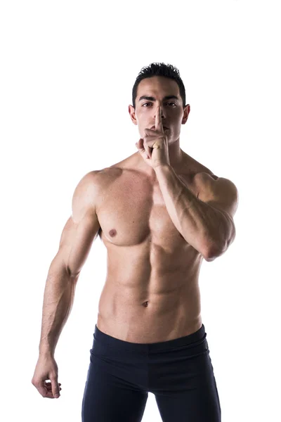 Young man doing shut up sign with finger on lips — Stock Photo, Image