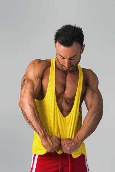 Muscular man pulling down tanktop on torso — Stock Photo, Image
