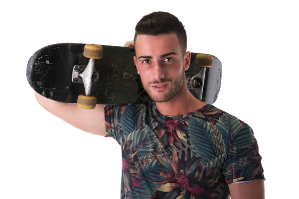 Handsome young man holding skateboard on his shoulder — Stock Photo, Image