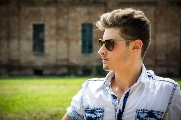 Handsome young man outdoors wearing sunglasses — Stock Photo, Image