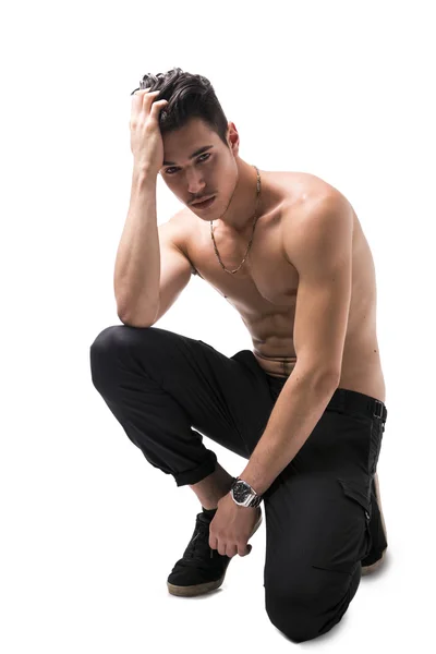 Lean athletic shirtless young man sitting, isolated — Stock Photo, Image