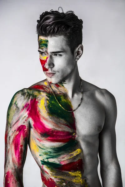 Hombre joven atractivo sin camisa, piel todo pintado con colores —  Fotos de Stock