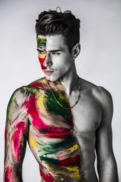 Attractive young man shirtless, skin painted all over with colors — Stock Photo, Image