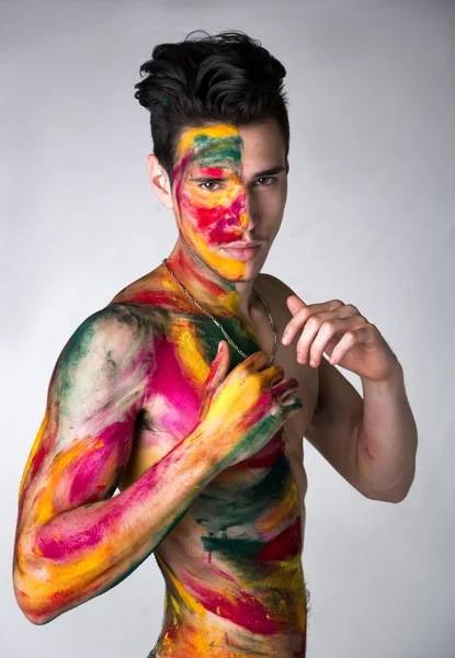 Hombre joven atractivo sin camisa, piel todo pintado con colores —  Fotos de Stock