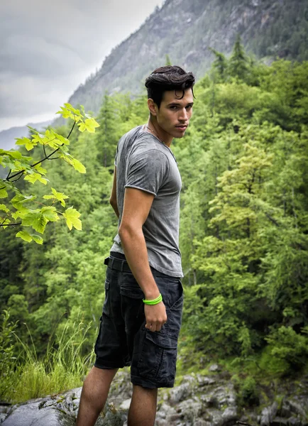 Beau jeune homme randonnée dans des paysages de montagne verte luxuriante — Photo
