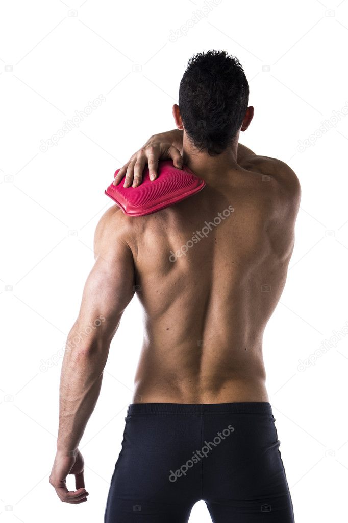 Back of muscular man with shoulder pain, holding hot water bottle