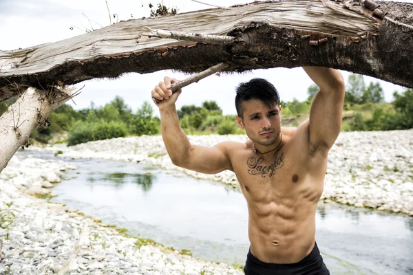 Jonge bodybuilder op het strand — Stockfoto