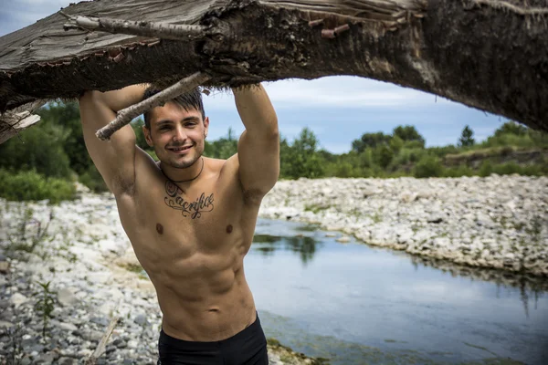 Unga bodybuilder på stranden — Stockfoto