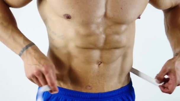 Muscular fisiculturista homem medindo barriga com fita métrica — Vídeo de Stock