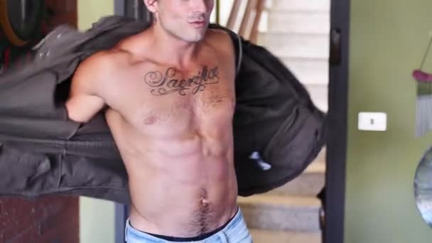 Junger fitter Mann öffnet Pullover auf nacktem muskulösen Oberkörper — Stockvideo