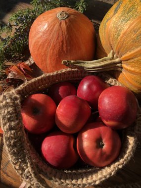Balkabağı, elma ve çiçekler masada.