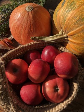 Balkabağı, elma ve çiçekler masada.