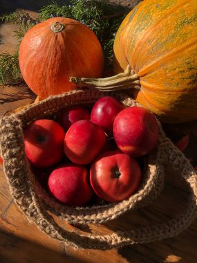 Balkabağı, elma ve çiçekler masada.