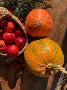 Balkabağı, elma ve çiçekler masada.