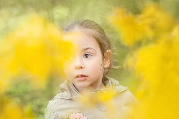 春の女の子の子供は花の後ろに隠れて選択的な焦点 — ストック写真