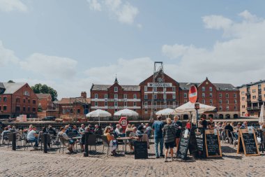 York, İngiltere - 22 Haziran 2021: Eski Romalılar tarafından İngiltere 'nin kuzeydoğusunda duvarlarla çevrili bir şehir olan Ouse Nehri' nin kıyısındaki bir barın açık hava masalarındaki insanlar.