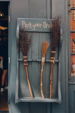 York, UK - June 22, 2021: Park your broom display outside Facade of The Shop That Must Not Be Named, a Harry Potter themed shop on Shambles, an old street in York dating back to the fourteenth century clipart