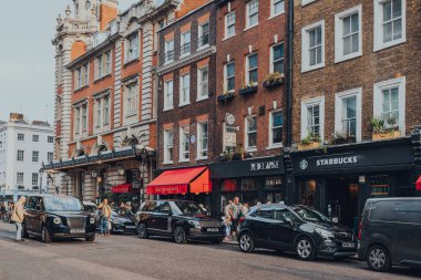 Londra, İngiltere - 09 Ekim 2021: Covent Garden 'da bir çok mağazası ve restoranı olan ünlü bir turizm alanı olan kafelerin ve restoranların önüne park edilmiş arabalar.