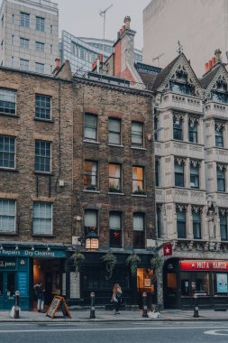 Londra, İngiltere - 09 Ekim 2021: Kadın Fleet Caddesi 'ndeki dükkanların önünden geçiyor, büyük bir kısmı Londra' da ve Roma zamanından bu yana önemli bir güzergah..