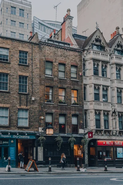 Londra, İngiltere - 09 Ekim 2021: Kadın Fleet Caddesi 'ndeki dükkanların önünden geçiyor, büyük bir kısmı Londra' da ve Roma zamanından bu yana önemli bir güzergah..