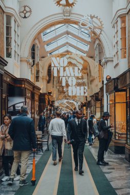 Londra, İngiltere - 02 Ekim 2021: Londra 'daki orijinal lüks mağaza olan Burlington Arcade' de James Bond 007 'nin altında yürüyen insanlar.