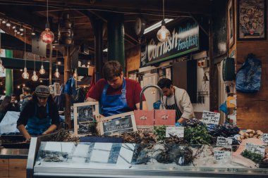 Londra, İngiltere - 17 Ekim 2021: Londra 'nın en büyük ve en eski gıda pazarlarından biri olan Borough Market' teki Shellseekers balıkçı tezgahında çalışan personel. Önplanda seçmeli odak.