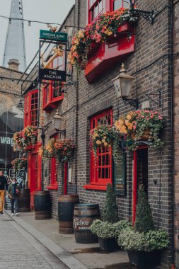Londra, İngiltere - 17 Ekim 2021: Bankside 'daki Anchor Pub' ın kırmızı cephesi, tarihi bir yer ama Shakespeare zamanında burada bulunan nehir kenarındaki hanlardan hayatta kalan tek kişi..