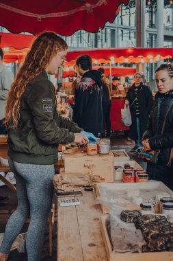 Londra, İngiltere - 17 Ekim 2021: Satıcı Londra 'nın en büyük ve en eski gıda pazarlarından biri olan Borough Market' teki bir tezgahta tadımlık yapıyor..