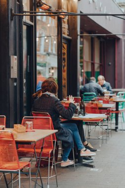 Londra, İngiltere - 23 Ekim 2021: Exmouth Market 'te bir restoranın açık masalarında sohbet eden kadınlar, Clerkenwell, Islington' da yarı yayalara ayrılmış bir cadde ve ünlü bir sokak pazarı.