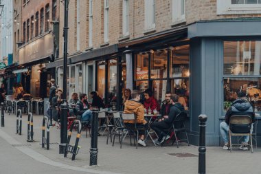 Londra, İngiltere - 23 Ekim 2021: Exmouth Market 'te açık hava masalarında oturan insanlar, Clerkenwell, Islington' da yarı yayalara ayrılmış bir cadde ve ünlü bir sokak pazarı.