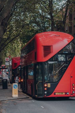 Londra, İngiltere - 23 Ekim 2021: Islington, Londra 'da bir otobüs durağında modern kırmızı çift katlı otobüsler. İkonik kırmızı otobüsler Londra ağı için taşımacılığın ayrılmaz bir parçasıdır.