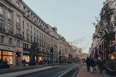 Londra, İngiltere - 23 Kasım 2021: Regent Caddesi, Londra 'nın batı ucunda büyük bir alışveriş caddesi, dev asılı melek Noel ışıklarıyla süslenmiş, seçici odaklı.