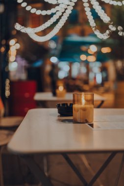 Kışın bir restoranın açık hava masasında mum yaktım, rahat atmosfer, seçici odak, bokeh.