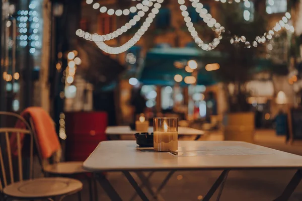 Kışın bir restoranın açık hava masasında mum yaktım, rahat atmosfer, seçici odak, bokeh.