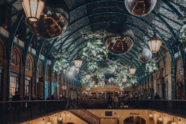 Londra, İngiltere - 23 Kasım 2021: Londra 'nın en popüler turizm merkezlerinden biri olan Covent Garden Market' te Noel süslemeleri, ökseotu ve dev şenlik mücevherleri.