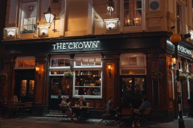London, UK - November 23, 2021: People sitting at the outdoor tables of The Crown pub on Seven Dials in Covent Garden, one of the most popular tourist areas in London, UK.