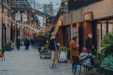 London, UK - January 01, 2022: People queue outside a cafe in Coal Drops Yard, a shopping destination and foodie hotspot near King's Cross St Pancras stations opened in 2018.