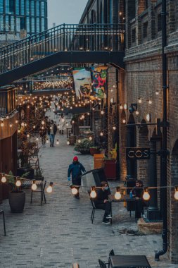 London, UK - January 01, 2022: High angle view of people walking past the shops in Coal Drops Yard, a shopping destination and foodie hotspot near King's Cross St Pancras stations opened in 2018.