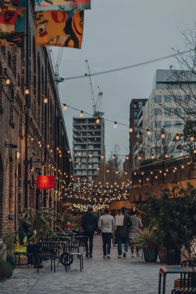 London, UK - January 01, 2022: People walking past the shops in Coal Drops Yard, a shopping destination and foodie hotspot near King's Cross St Pancras stations opened in 2018.