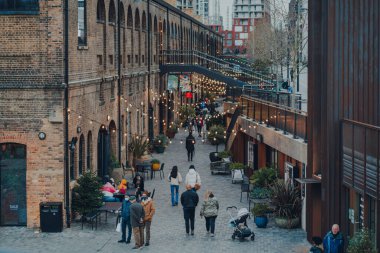 Londra, İngiltere - 01 Ocak 2022: Kömür Yard 'da ışıkların altında yürüyen insanların yüksek açılı görüntüsü, King' s Cross St Pancras istasyonları yakınlarındaki bir alışveriş merkezi ve gurme merkezi 2018 yılında açıldı..
