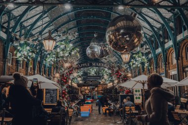 Londra, İngiltere - 23 Kasım 2021: Londra 'nın en popüler turizm merkezlerinden biri olan Covent Garden Market' te Noel süslemeleri, ökseotu ve dev şenlik mücevherleri.