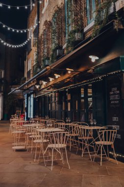 Londra, İngiltere - 23 Kasım 2021: Covent Garden 'daki Neal' s Yard 'daki bir restoranın açık hava masaları, Londra' nın ünlü ve tipik olarak yoğun turistik alanlarından biri..