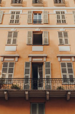 Nice, Fransa 'da balkonu olan geleneksel renkli apartman binasının alçak açılı görüntüsü.