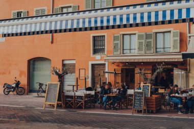 Nice, Fransa - 10 Mart 2022: Cours Saleya 'daki Barbacane Bar' ın açık masalarında oturan insanlar, Old Town of Nice 'in günlük açık hava pazarlarıyla tanınan bir caddesi..