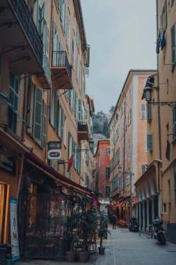 Nice, Fransa - 10 Mart 2022: Fransız Rivierası 'nda ünlü bir turizm merkezi olan Eski Nice Kasabası' ndaki dar bir caddede restoranların manzarası.