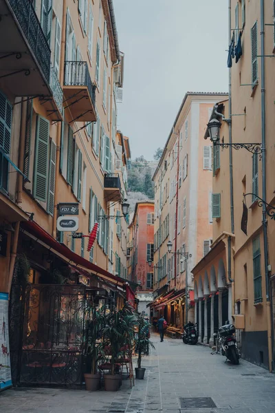 Nice, Fransa - 10 Mart 2022: Fransız Rivierası 'nda ünlü bir turizm merkezi olan Eski Nice Kasabası' ndaki dar bir caddede restoranların manzarası.