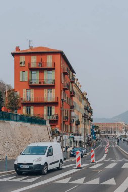 Nice, Fransa - 11 Mart 2022: Nice limanındaki geleneksel bir konut binası, Fransız Riviera 'sındaki ünlü bir turizm merkezi, arabayla geçen, hareket bulanıklığı.